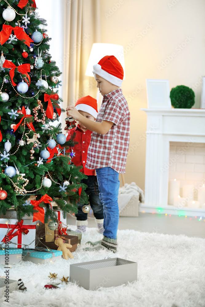 Two cute small brothers decorating Christmas tree