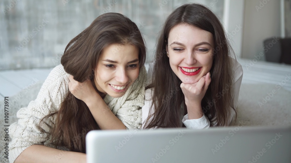 two beautiful girls look the laptop in summer cafe two beautiful girls look the laptop in summer cafe