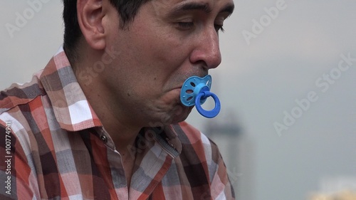 Infantile Man Using Baby Pacifier photo