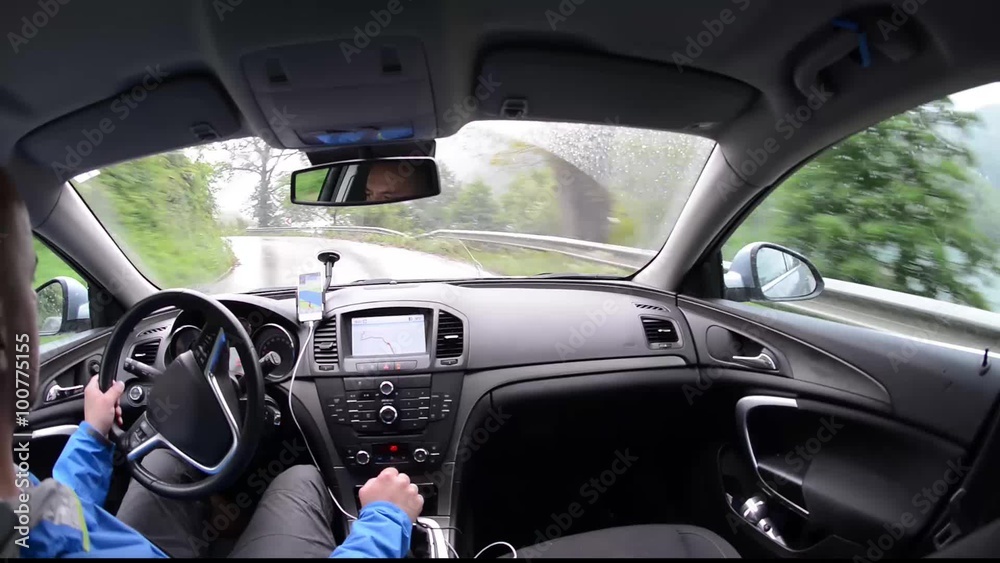 man driving a car with gps navigation system and phone smart phone app on rain and wet road man driving a car with gps navigation system and phone smart phone app on rain and wet road