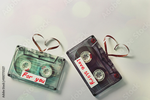 Retro audio cassettes with tapes in shape of hearts on white background