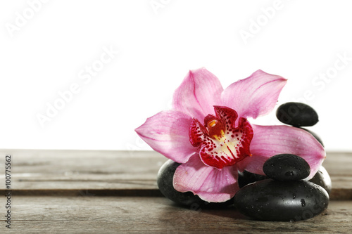 Beautiful pink orchid and spa stones isolated on white