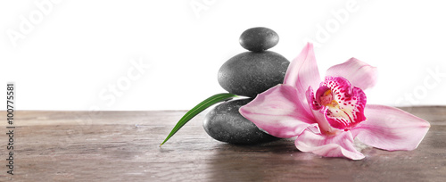 Spa pebbles and beautiful pink orchid on white background