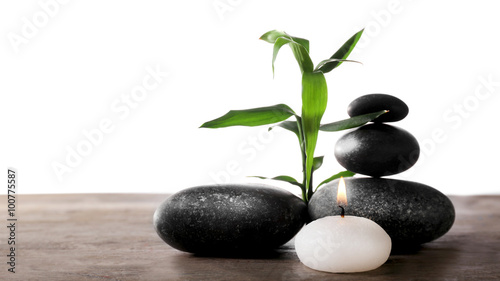 Spa still life with green plant  pebbles and candlelight on white background