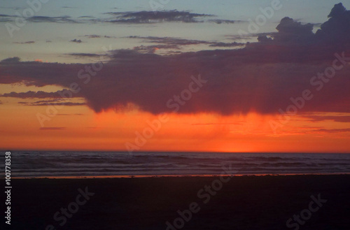 Cloudy Sunset Over the Ocean with Waves in the Foreground