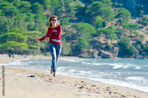 Girl running along the shoreline, girl runs on the beach. jumping happy on the beach 