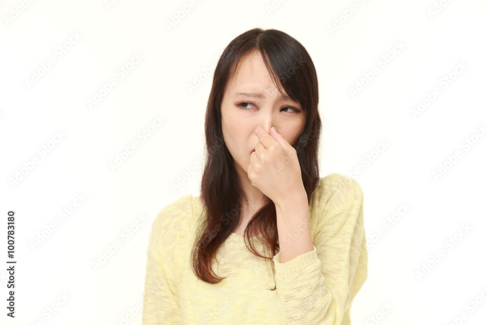 Japanese woman holding her nose because of a bad smell Japanese woman holding her nose because of a bad smell