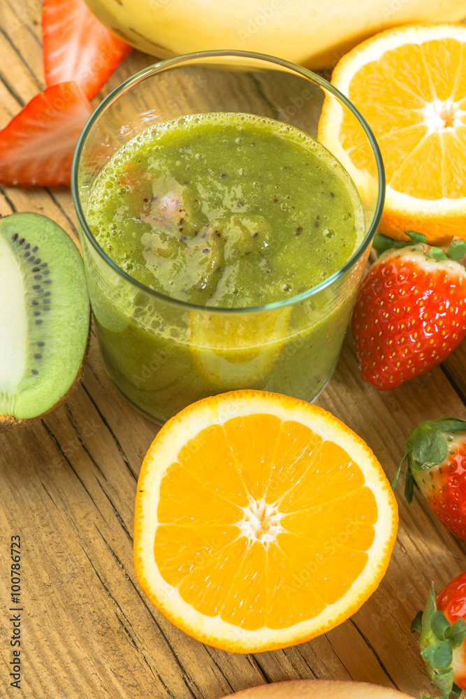 Natural smoothie surrounded by kiwi fruit on wooden base Natural smoothie surrounded by kiwi fruit on wooden base