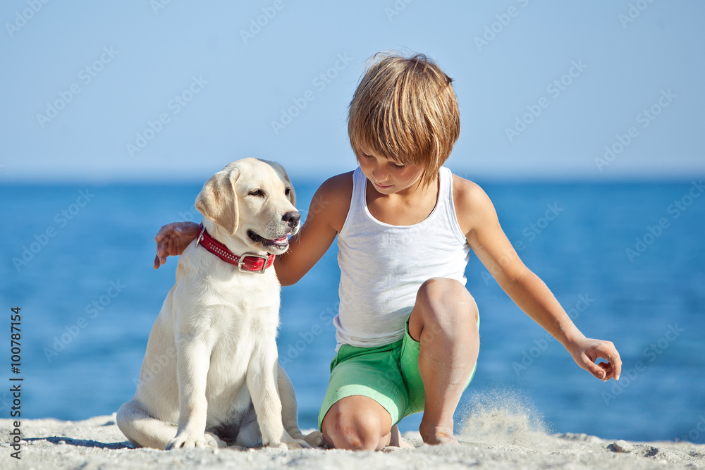 Happy kid with a dog on the beach Happy kid with a dog on the beach