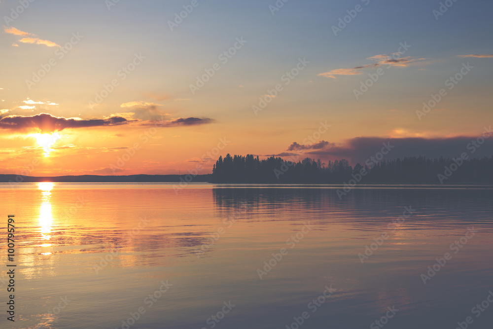 A magnificent sunset by the lake in Finland. Image has a vintage effect applied.