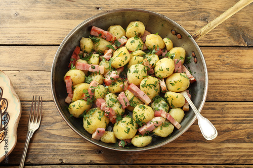 vista dall'alto patate cucinate con bacon in padella di metallo sfondo rustico