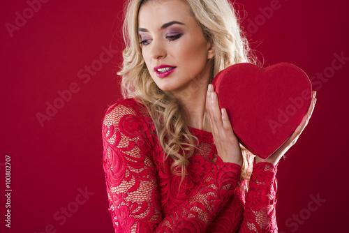Woman holding heartshape box next to her face