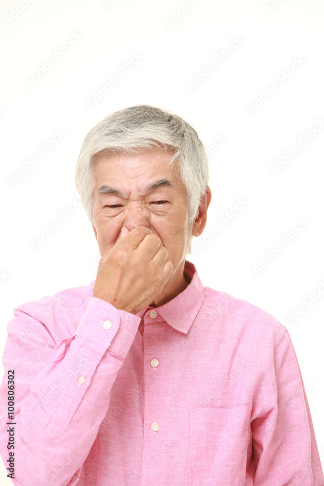 senior Japanese man holding his nose senior Japanese man holding his nose