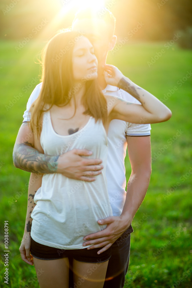 Beautiful young loving couple hugging in nature. The concept of good mood Beautiful young loving couple hugging in nature. The concept of good mood