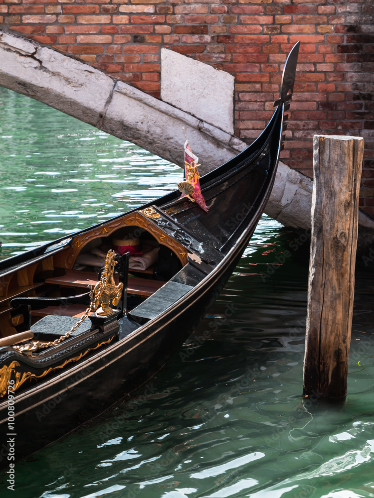 Close up of Gondola's Iron Prow and Antique Bridge in Venice