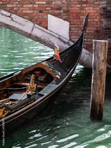 Close up of Gondola's Iron Prow and Antique Bridge in Venice