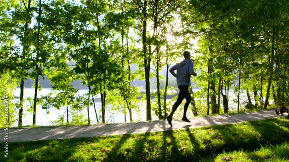 Man running in park at morning during sun rise slow motion Man running in park at morning during sun rise slow motion