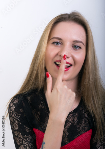 Close-up of attractive brunette woman putting a finger on her nose