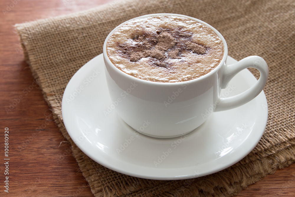 A cup of cappuccino at the wooden table A cup of cappuccino at the wooden table