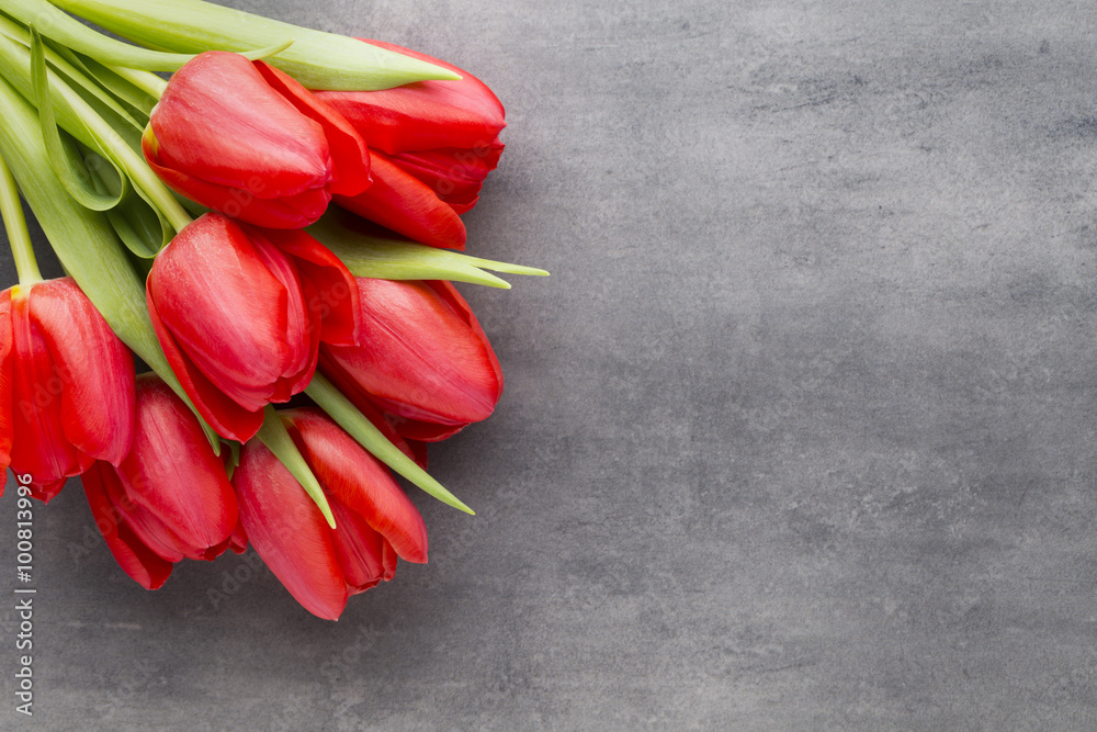 Obraz premium Red tulips on a wooden background.