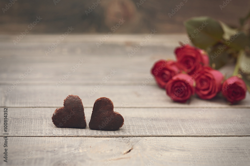 Two homemade cookies and roses in the background Two homemade cookies and roses in the background