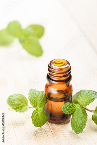 fresh mint essential oil on wooden board