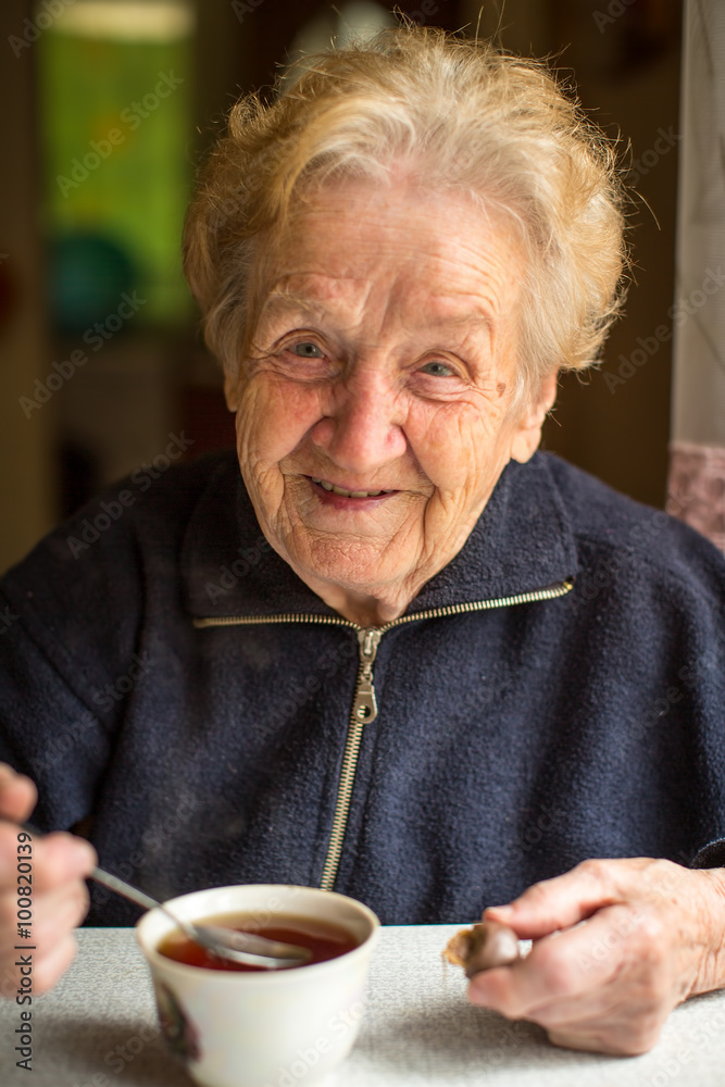 Elderly woman drinking tea in the kitchen. Elderly woman drinking tea in the kitchen.