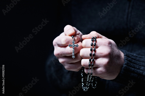 caucasian hands wrapped in a Christian rosary. faith, devotion, religion
