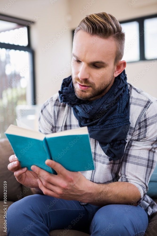 Handsome man reading a book on the couch Handsome man reading a book on the couch