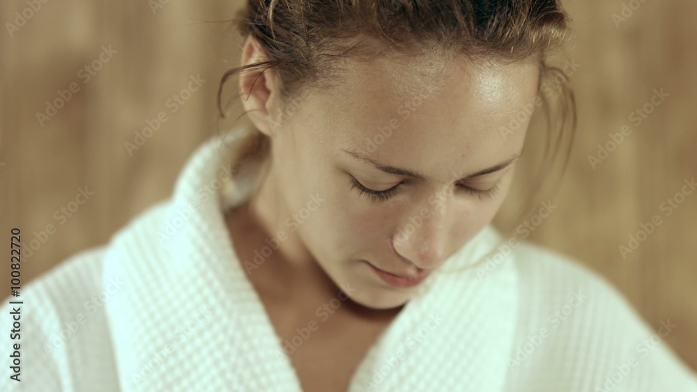 Sweaty woman in a bathrobe relaxing in a sauna Sweaty woman in a bathrobe relaxing in a sauna