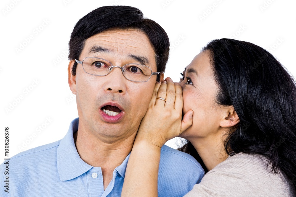 Woman whispering into partners ear Woman whispering into partners ear