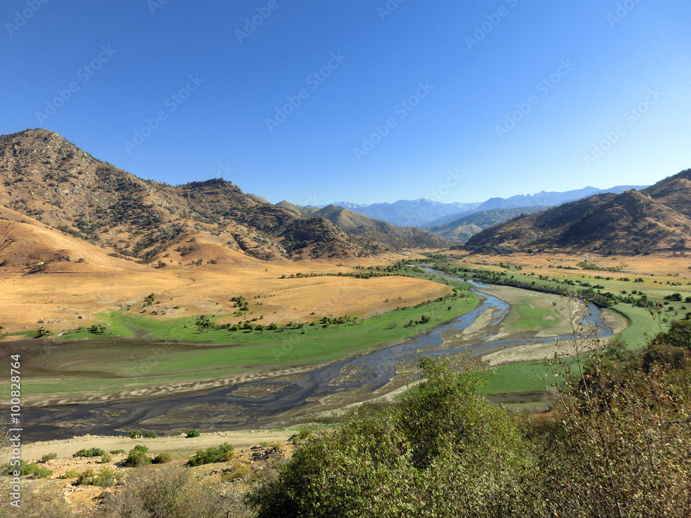 Landscape photo showing fertile valley and river with mountains