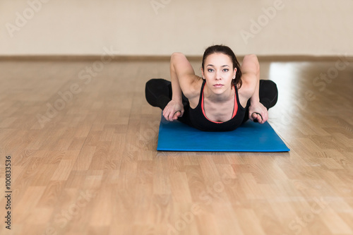 Young sports woman practicing yoga Pose. Indoor gym. photo