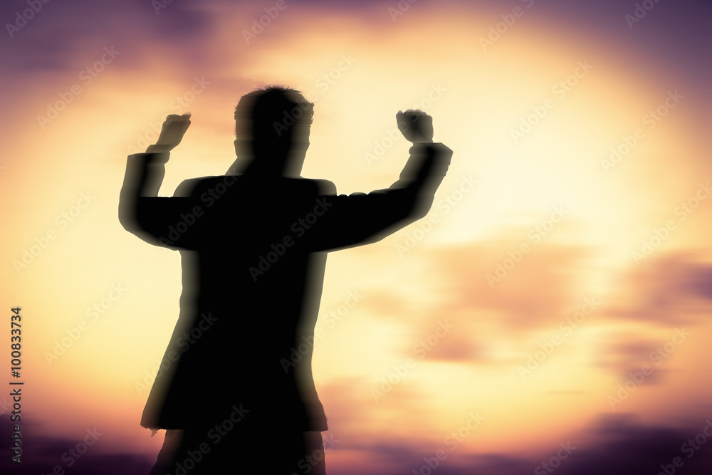 Motion silhouette of man showing his hand on sunset sky background, Successful business concept.