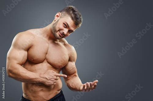 shirless muscular man holding copy space photo