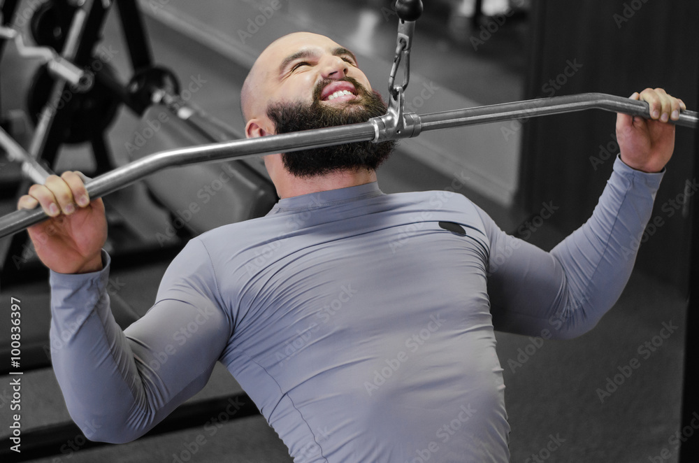Muscular bodybuilder training in the gym, doing pulldown exercises for muscles
Muscular bodybuilder training in the gym, doing pulldown exercises for muscles