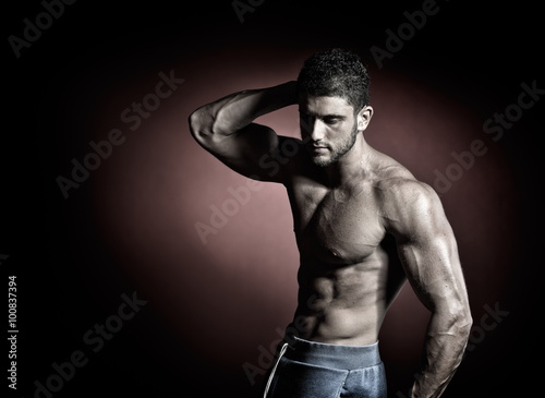 athletic young man portrait in studio with dark background © bereta