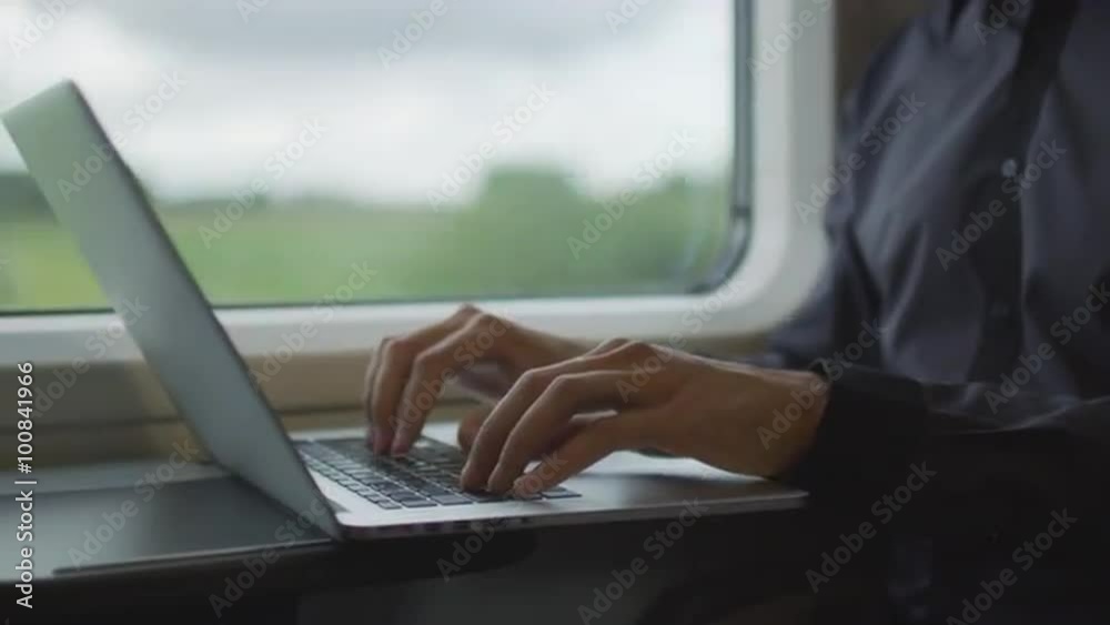 Man Working on Laptop in During Traveling on Train. Shot on RED Cinema Camera. Man Working on Laptop in During Traveling on Train. Shot on RED Cinema Camera.