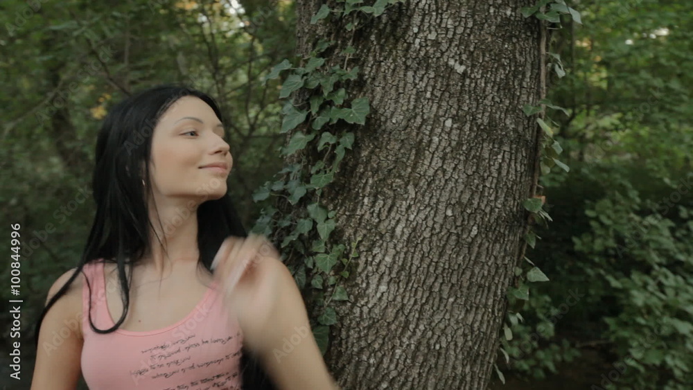 Beautiful girl standing near the tree in the forest Beautiful girl standing near the tree in the forest