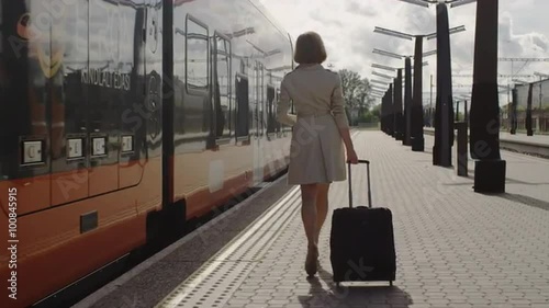 Confident Woman With Luggage Walking on Railway Station