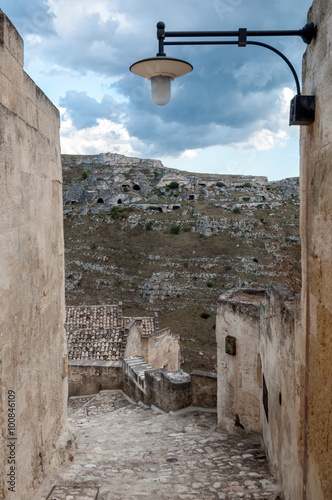 Passage with lantern leading to view of ancient caverns of Sassi photo