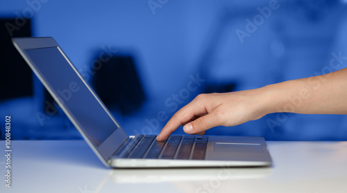 Businessman pressing modern laptop computer on colorful backgrou