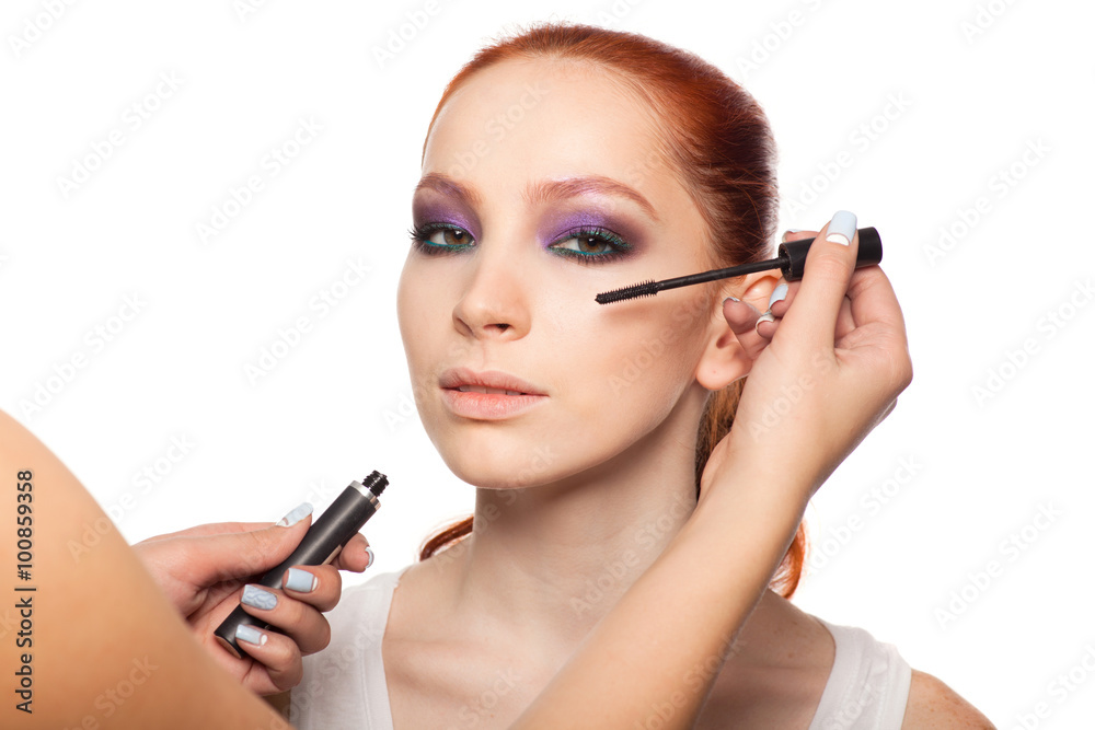 Professional Make-up artist doing glamour with red hair model makeup. Isolated background. Professional Make-up artist doing glamour with red hair model makeup. Isolated background.