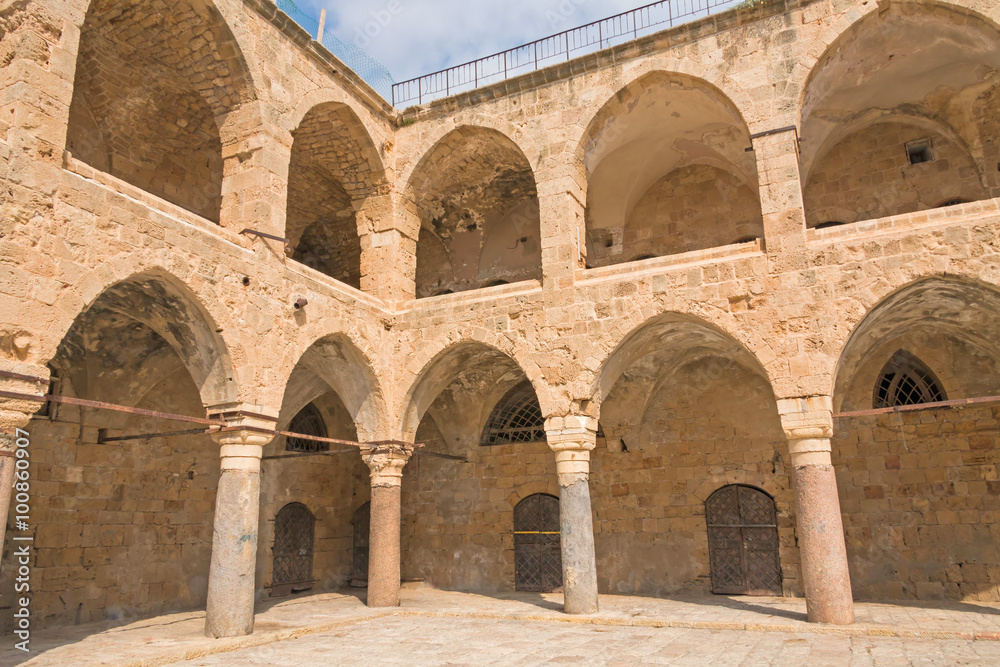 Arched gallery of Khan al-Umdan viewed from paved courtyard. Old city of Acre, Israel.
