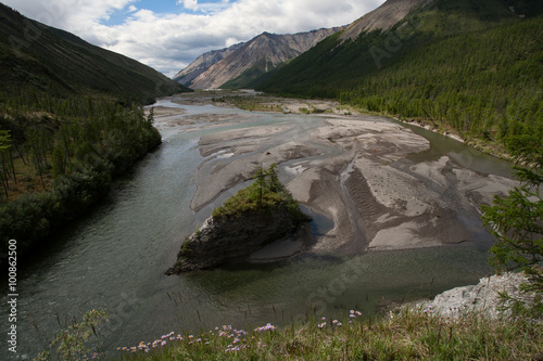 A rocky island in the bed of a mountain river. Omulyovka River. Magadan Region. Russia.