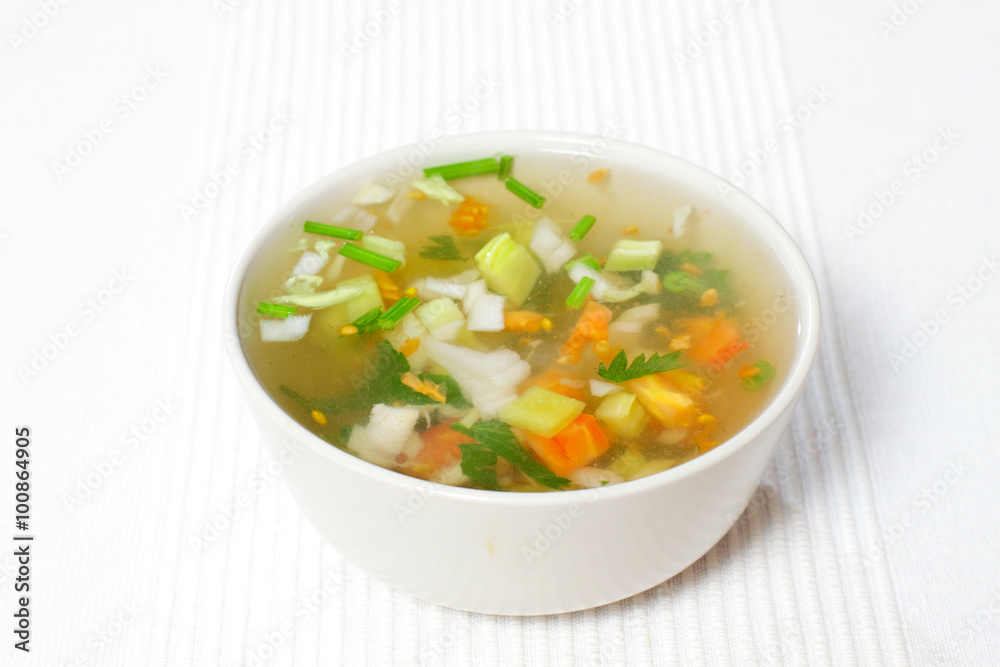 chopped soup ingredients: carrots, onions and celery cooking in a stainless steel pot