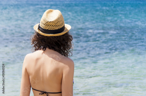 Beach vacation. Beautiful woman in sunhat and bikini looking view of beach ocean on hot summer day. Photo from Fuerteventura Island, Spain