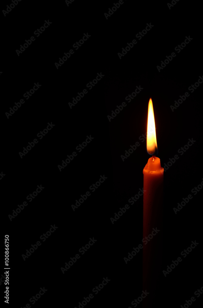 light of candle on black background