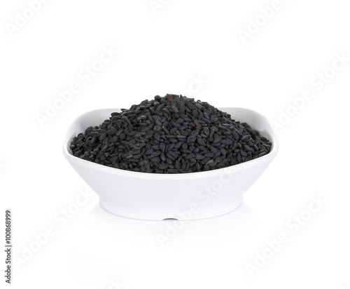 black sesame seeds in bowl on white background