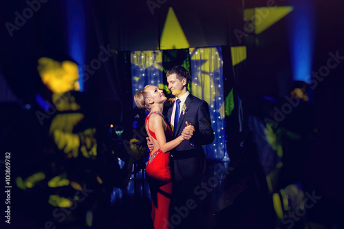 Slika na platnu stylish luxury bride in red dress and groom dancing in a restaur
